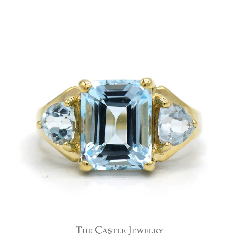 ladies rings fashion statement -Emerald Cut Blue Topaz Ring with Trillion Cut Topaz Sides in 10k Yellow Gold